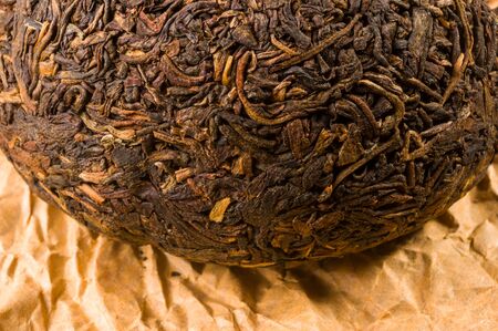 Chinese pressed PU-erh tea on wrapping paper on a bamboo Mat, close-upの写真素材