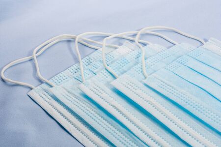 Background concept for news about the novel coronavirus COVID-19 pandemic, antiviral medical mask for protection against coronavirus. Surgical protective mask. Medical respiratory bandage face and thermometer, lettering on copy space.の写真素材