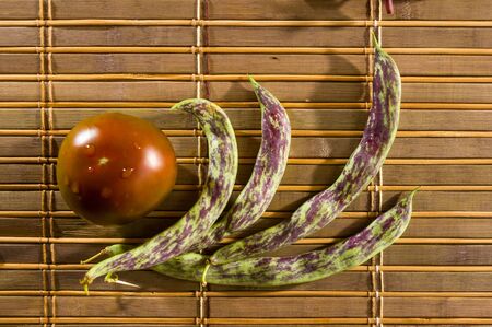 Still life - asparagus beans, purple Basil, yellow and chocolate tomatoes on bamboo Matの写真素材