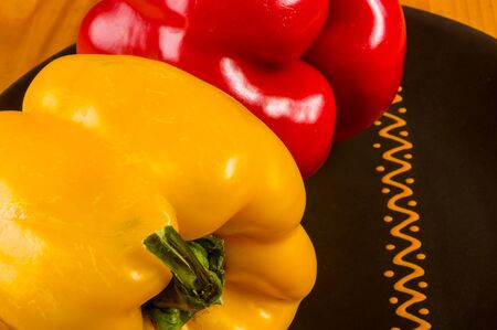 a colorful mix of the freshest red and yellow paprika, bell pepper in ceramic plate on wooden background, close upの写真素材