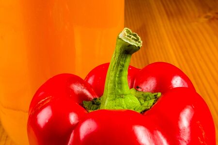 fresh red paprika, bell pepper and a bottle of pumpkin juice, close upの写真素材
