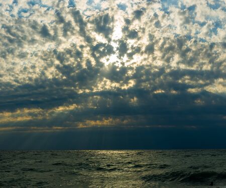 Summer sea sunset, the sun, waves and clouds, beautiful dramatic lightingの写真素材