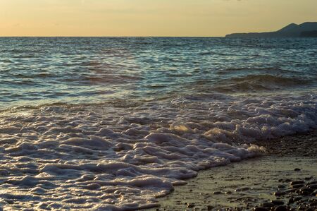 Summer sea sunset, the sun, waves and clouds, beautiful dramatic lightingの写真素材