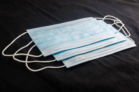 Background concept for news about the novel coronavirus COVID-19 pandemic, antiviral medical mask for protection against coronavirus. Surgical protective mask. Medical respiratory bandage face and thermometer, lettering on copy space.の写真素材