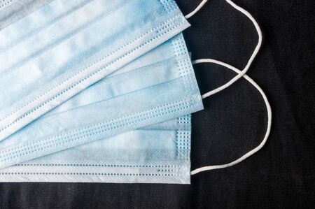 Background concept for news about the novel coronavirus COVID-19 pandemic, antiviral medical mask for protection against coronavirus. Surgical protective mask. Medical respiratory bandage face and thermometer, lettering on copy space.の写真素材