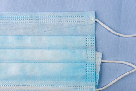 Background concept for news about the novel coronavirus COVID-19 pandemic, antiviral medical mask for protection against coronavirus. Surgical protective mask. Medical respiratory bandage face and thermometer, lettering on copy space.の写真素材