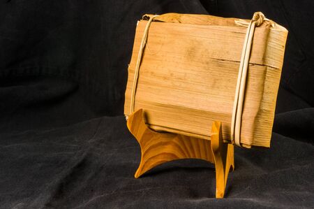 Chinese pressed PU-erh tea in bamboo leaf packaging on a special stand, close-upの写真素材