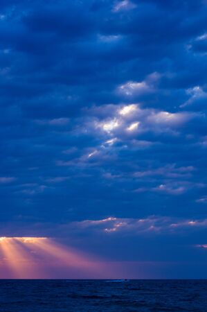 Summer sea sunset, the sun, waves and clouds, beautiful dramatic lightingの写真素材