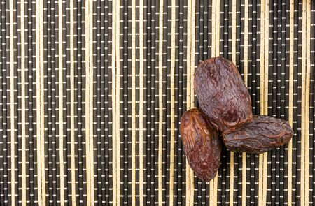 Big luxury dried date fruit on the bamboo mat, kurma ramadan kareem concept.の写真素材