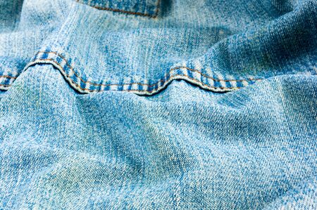clothing items blue washed faded jeans cotton fabric texture with seams, clasps, buttons and rivets, macroの写真素材