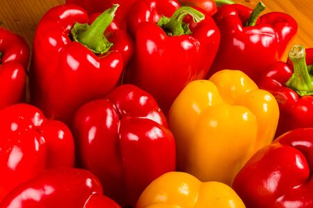 a colorful mix of the freshest red and yellow paprika, bell pepper on wooden background, close upの写真素材