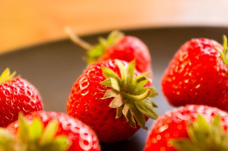 fresh ripe berries strawberries on black ceramic plateの写真素材