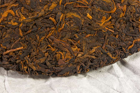 Chinese pressed PU-erh tea on wrapping paper, close-upの写真素材