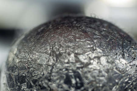 Unusual abstract techno view of crumpled aluminum foil ball, close-up, macro photoの写真素材