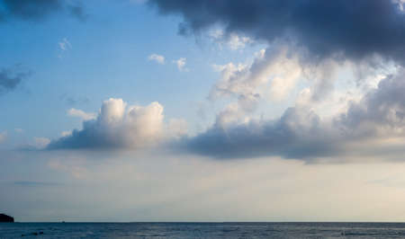 sea landscape is a pebbly beach with waves in white foam, a beautiful sky with clouds, a warm summer dayの写真素材