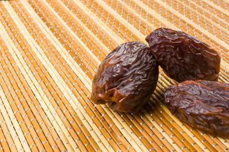 Big luxury dried date fruit on the bamboo mat, kurma ramadan kareem concept.の写真素材