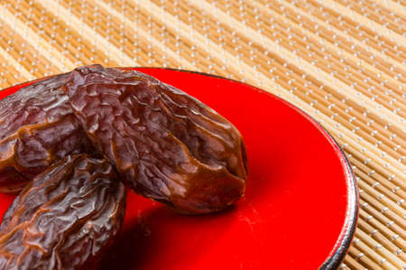 Big luxury dried date fruit in bowls on the bamboo mat, kurma ramadan kareem concept.の写真素材
