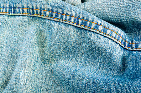 clothing items blue washed faded jeans cotton fabric texture with seams, clasps, buttons and rivets, macroの写真素材