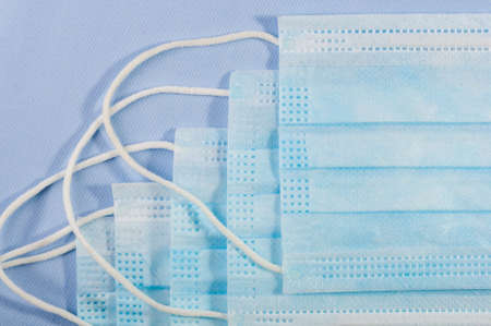 Background concept for news about the novel coronavirus COVID-19 pandemic, antiviral medical mask for protection against coronavirus. Surgical protective mask. Medical respiratory bandage face and thermometer, lettering on copy space.の写真素材