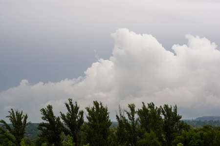 Spring city landscape - green trees and sky with clouds on a Sunny dayの写真素材