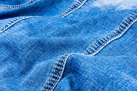 clothing items blue washed faded jeans cotton fabric texture with seams, clasps, buttons and rivets,...
