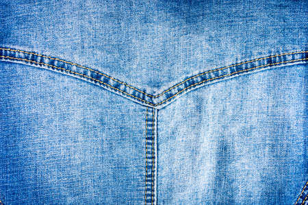 clothing items blue washed faded jeans cotton fabric texture with seams, clasps, buttons and rivets, macroの写真素材
