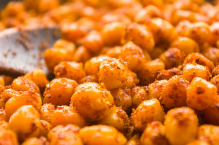 Cooking chickpeas with spices in a pan, close upの写真素材