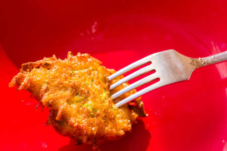 Fried vegetable fritters with zucchini, carrots, herbs, eggs, seasonings and cheese, close-up, selective focusの写真素材