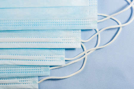 Background concept for news about the novel coronavirus COVID-19 pandemic, antiviral medical mask for protection against coronavirus. Surgical protective mask. Medical respiratory bandage face and thermometer, lettering on copy space.の写真素材