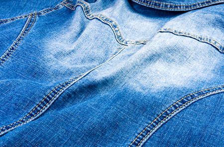 clothing items blue washed faded jeans cotton fabric texture with seams, clasps, buttons and rivets, macroの写真素材