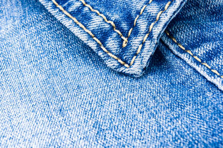 clothing items blue washed faded jeans cotton fabric texture with seams, clasps, buttons and rivets, macroの写真素材