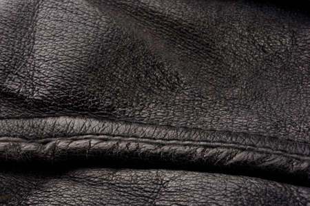 Old vintage genuine soft black leather texture background, top layer with pores and scratches, macro