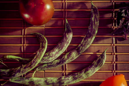 Still life - asparagus beans, purple Basil, yellow and chocolate tomatoes on bamboo Matの写真素材