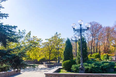 Autumn cityscape on a Sunny day - yellow autumn trees in the Park, colorful red and orange leaves,...