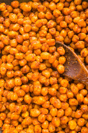 Cooking chickpeas with spices in a pan, close upの写真素材
