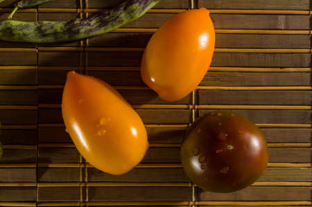 Still life - asparagus beans, purple Basil, paprika, yellow and chocolate tomatoes on bamboo Matの写真素材