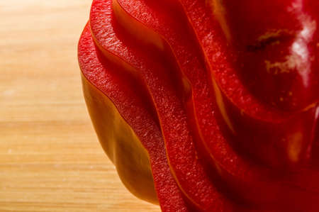 stacked pile of sliced fresh red paprika, bell pepper on bamboo cutting Board, close upの写真素材