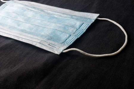 Background concept for news about the novel coronavirus COVID-19 pandemic, antiviral medical mask for protection against coronavirus. Surgical protective mask. Medical respiratory bandage face and thermometer, lettering on copy space.の写真素材