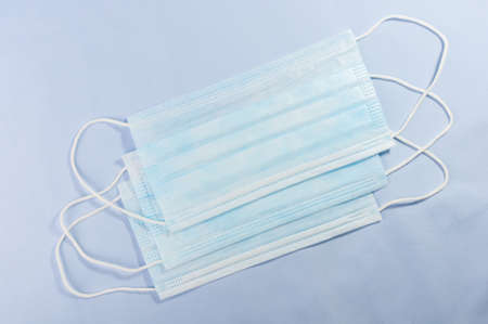 Background concept for news about the novel coronavirus COVID-19 pandemic, antiviral medical mask for protection against coronavirus. Surgical protective mask. Medical respiratory bandage face and thermometer, lettering on copy space.の写真素材