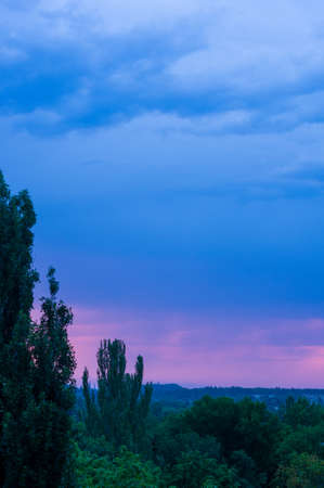 Landscape with dramatic light - beautiful golden sunset with saturated sky and clouds, peaceful nature serene background.の写真素材
