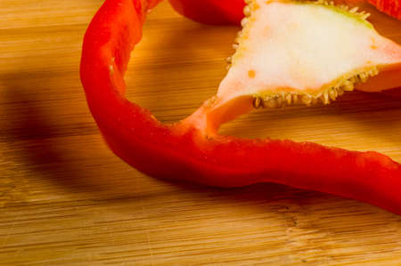 sliced fresh red paprika, bell pepper on bamboo cutting board, close upの写真素材
