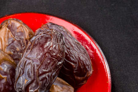 Big luxury dried date fruit in bowls on the dark surface, kurma ramadan kareem concept.の写真素材