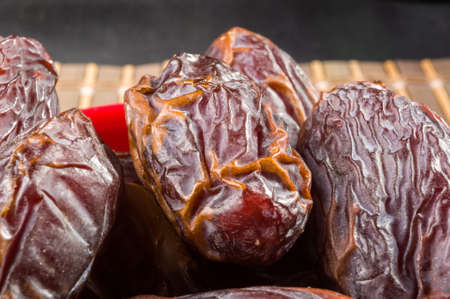 Big luxury dried date fruit in bowls on the bamboo mat, kurma ramadan kareem concept.の写真素材