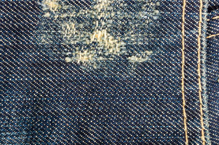 clothing items blue washed faded jeans cotton fabric texture with seams, clasps, buttons and rivets, macroの写真素材