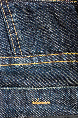 clothing items blue washed faded jeans cotton fabric texture with seams, clasps, buttons and rivets, macroの写真素材