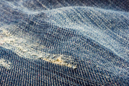 clothing items blue washed faded jeans cotton fabric texture with seams, clasps, buttons and rivets, macroの写真素材