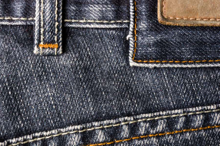 clothing items blue washed faded jeans cotton fabric texture with seams, clasps, buttons and rivets, macroの写真素材