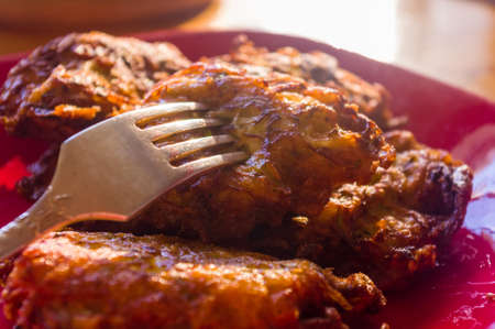 Fried vegetable fritters with zucchini, carrots, herbs, eggs, seasonings and cheese, close-up,...