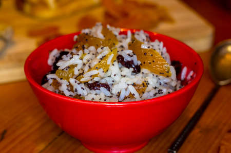 handmade preparation of treats for traditional Orthodox Christmas - rice pudding with fruits, cranberries, honey, nuts, Church candles on a wooden tableの写真素材