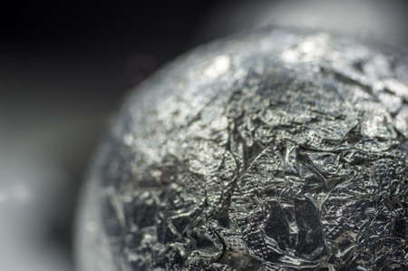 Unusual abstract techno view of crumpled aluminum foil ball, close-up, macro photoの写真素材